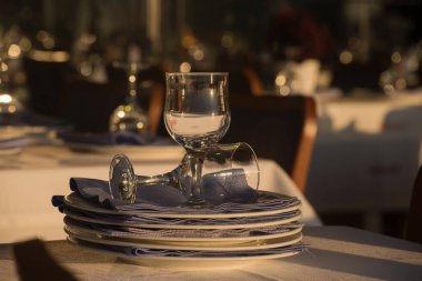 Galata Köprüsü, İstanbul 'da bir sokak kafesinde masa kuruluyor. Restoranın misafirleri için şarap kadehleri ve tabaklar hazır..