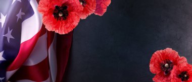 Amerika Birleşik Devletleri resmi bayrağı ve kırmızı gelincikli Anma Günü Afişi koyu gri arka plan ve boş alana karşı.