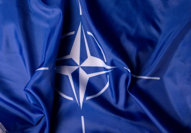 Ukrayna, Kiev - 10.04.2023. NATO resmi bayrağı gri arka plana karşı. Belirsizlik ve Çatışma Dünyasında Birlik ve Dayanıklılık Sembolü.