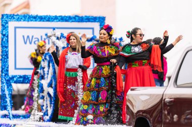Brownsville, Teksas, ABD - 26 Şubat 2022: Charro Days Grand International Parade, Geleneksel Meksika kıyafetleri giyen kadınlar, bir şamandıraya biniyorlar, Walmart 'ı tanıtıyorlar