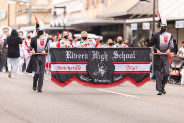 Brownsville, Texas, USA - February 26, 2022: Charro Days Grand International Parade, Members of the Rivera High School Raider Marching Band performing at the parade clipart