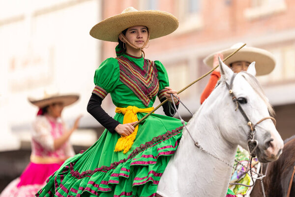 Brownsville, Texas, USA - February 26, 2022: Charro Days Grand International Parade, Members of Vaqueros y Charros Unidos, wearing traditional clothing, riding horses during the parade