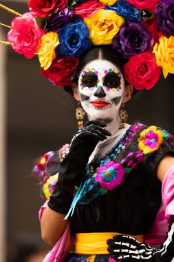 Matamoros, Tamaulipas, Meksika - 1 Kasım 2022: Dia de los Muertos Parade, Catrina geleneksel kıyafetler giyiyor ve çiçek dolu bir elbise giyiyor