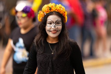 Matamoros, Tamaulipas, Meksika - 1 Kasım 2022: Dia de los Muertos Parade, Catrina geleneksel kıyafet ve çiçek başlıklı elbise giyiyor