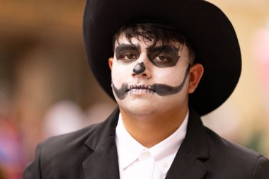 Matamoros, Tamaulipas, Meksika - 1 Kasım 2022: Dia de los Muertos Parade, Kafatası boyası giyen, geleneksel giysiler giyen genç adam