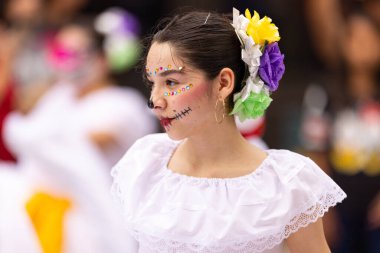 Matamoros, Tamaulipas, Meksika - 1 Kasım 2022: Dia de los Muertos Parade, Kafatası boyalı geleneksel kıyafetler giyen genç kadın