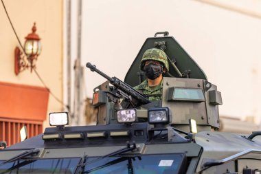 Matamoros, Tamaulipas, Mexico - September 16, 2022: Desfile 16 de Septiembre, Mexican Army soldier riding an armored personel carrier, handling a 50 cal Barrett clipart
