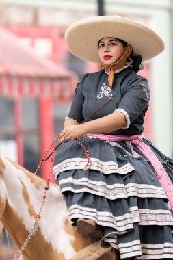 Matamoros, Tamaulipas, Meksika - 16 Eylül 2022: Desfile 16 de Septiembre, geleneksel kıyafet giyen genç kadın ata biniyor