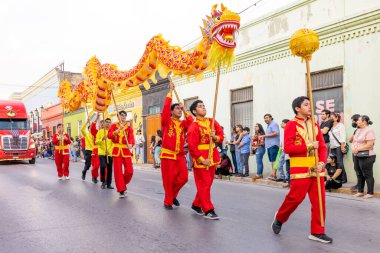 Matamoros, Tamaulipas, Meksika - 25 Şubat 2023: Fiestas Mexicanas Parade, Villa Freinet Cultural School öğrencileri, geleneksel Çin kıyafetleri giyerek, ejderha dansı yaparak