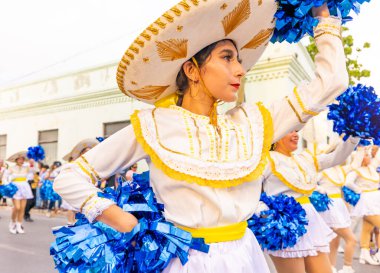 Matamoros, Tamaulipas, Meksika - 25 Şubat 2023: Fiestas Mexicanas Parade, Matamoros Teknoloji Enstitüsü 'nden ponpon kızlar, geleneksel kıyafetler giyip geçit töreninde dans ediyorlar.