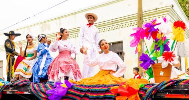 Matamoros, Tamaulipas, Meksika - 25 Şubat 2023: Fiestas Mexicanas Parade, TEC öğrencileri, geleneksel Meksika kıyafetleri giyiyorlar, geçit töreninde şamandıraya biniyorlar