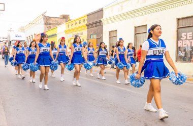 Matamoros, Tamaulipas, Meksika - 25 Şubat 2023: Fiestas Mexicanas Parade, UNS Lisesi 'nden ponpon kızlar geçit töreninde sahne alıyorlar.