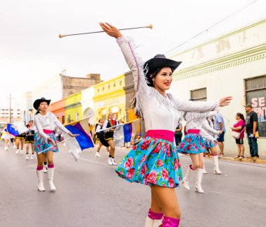 Matamoros, Tamaulipas, Meksika - 25 Şubat 2023: Fiestas Mexicanas Parade, Matamoros Teknoloji Enstitüsü 'nden ponpon kızlar, geleneksel kıyafetler giyip geçit töreninde dans ediyorlar.