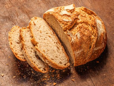 Top view of cutted wholegrain bread on dark ructic wooden background closeup. Copyspace.