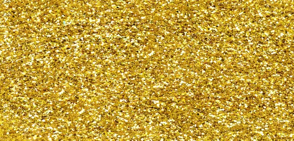 Gold glitter texture sparkling shiny background for Christmas card.  Twinkly golden  glitter lights grunge backgroun