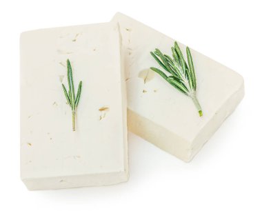 Feta peyniri izole. Beyaz arka planda Yunan fitaki peyniri parçaları ve biberiye otları. Üst yaşam