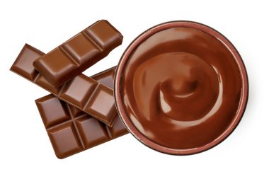 Bir kasede erimiş çikolata ve beyaz arka planda izole edilmiş çikolata parçaları. Çikolata akışı üst görüntüyü yaydı. Düz la