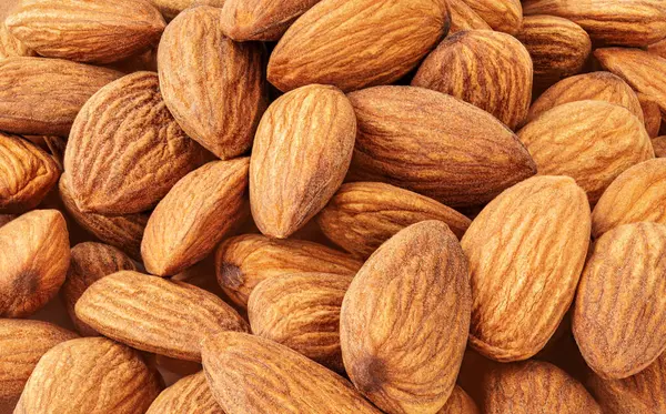 Badem fıstıklı arka plan. Badem fıstığından yapılmış yaratıcı bir düzen. Doku. Düz yatıyordu. Yemek konsepti. Badem deseni 