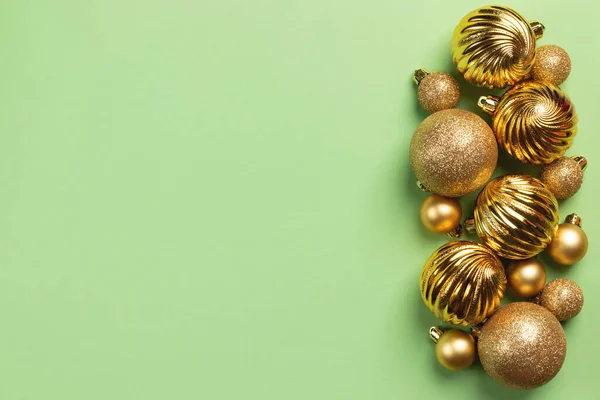 Christmas frame with golden glitter balls and decorations on green background with copy space
