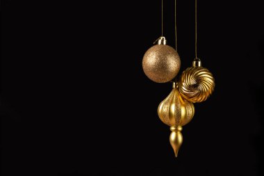 Siyah arka planda üç altın toplu noel kartı ve fotokopi alanı