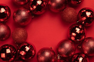 Kırmızı arkaplanda kırmızı noel süslemelerinin daire çerçevesini kopyala