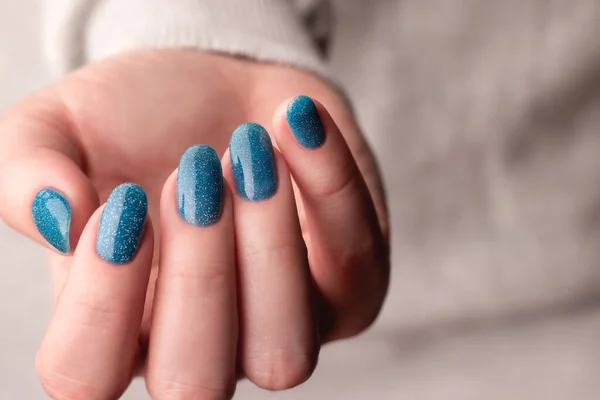 Женская Рука Сером Трикотажном Свитере Красивым Маникюром Синие Блестящие Ногти — стоковое фото