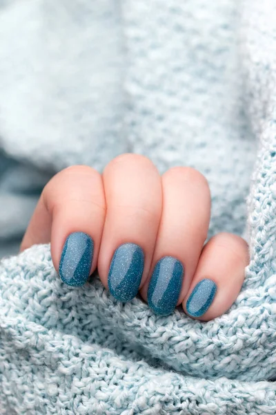 Ręka Kobiety Niebieskim Swetrze Dzianiny Pięknym Wakacyjnym Manicure Niebieskie Brokatowe — Zdjęcie stockowe