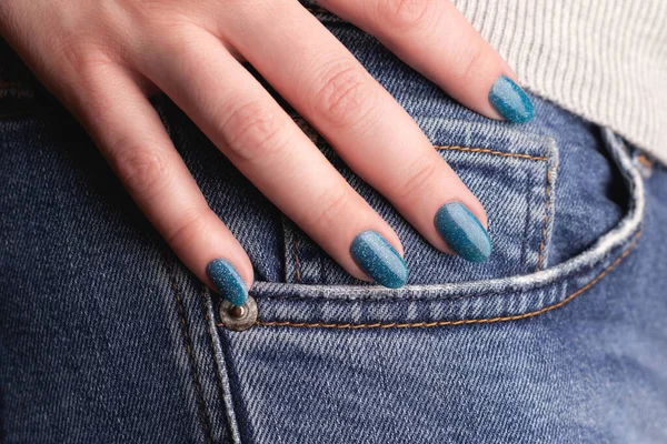 女性的手与美丽的指甲修整 蓝色闪亮的指甲牛仔裤牛仔 密切的手指 指甲护理概念 — 图库照片