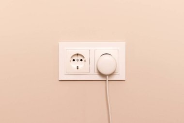 Modern bej duvarına takılmış yuvarlak prizli beyaz Avrupa elektrik prizleri grubu