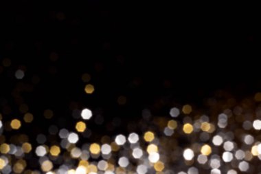 Altın ve gümüş, siyah arka planda bulanık bokeh ışıkları. Kutlamak için ışıldayan yıldızlar. Tasarımınız için üstüste