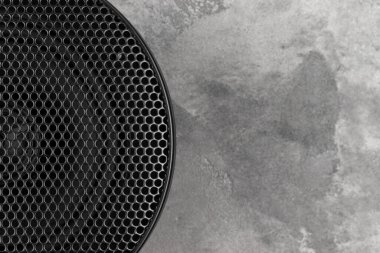 Gri beton arka plan yakın plan üzerinde waffle ızgara koruyucu kaplı şık araba akustik yuvarlak hoparlör. Modern müzik dokusu