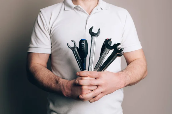 Man with bouquet of wrenches, spanners and screwdrivers. Fathers Day concept
