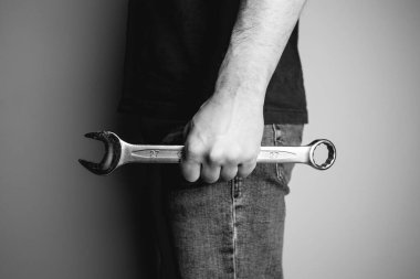 Bir elinde ingiliz anahtarı tutan adam. Yan görüş. Endüstriyel, mekanik ve DIY projeleri için ideal. Siyah beyaz fotoğraf