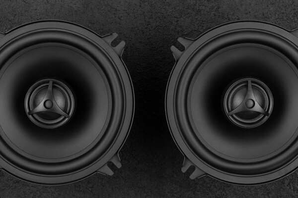 Stylish car audio acoustic round speakers on dark black background closeup