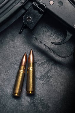 Kalaşnikof saldırı tüfeği için gri beton arka plan, üst görüş. Fişek 7.62 kalibre, AK 47 yakın çekim için.