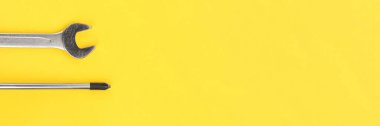 İş aletleri, ingiliz anahtarı ve tornavida parlak sarı arka plan pankartıyla. Panoramik ağ başlığı. Geniş ekran duvar kağıdı.