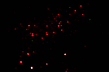 Kırmızı, siyah arka planda bokeh ışıkları bulanıklaştırdı. Kutlama için ışıltılı konfeti. Tasarımınız için üstüste.