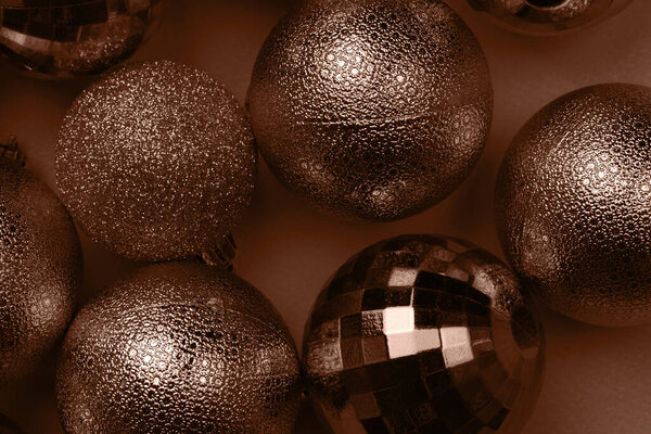 Christmas card with brown, mocha mousse glitter bauble balls on brown background. Demonstrating color, trend 2025 year