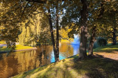 Riga 'da sonbahar, sonbahar renklerinde şehir kanalı manzarası 