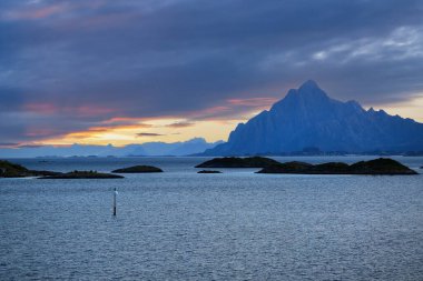 Yaz ortası güneşi gökyüzünde Lofoten adaları ve Norveç 'in Svolvaer kasabası yakınlarındaki fiyort Vestfjorden' da.