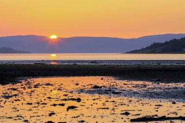 Norveç 'in Trondheim kenti yakınlarındaki Trondheim fiyortu ve kumlu sahil Oesanden' de sular alçak.