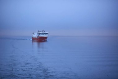 Norveç denizinde feribot ile sisli ve sisli bir gün doğumu. Fotoğraf Hurtigruten yolcu gemisinden çekildi.