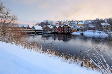 Trondheim 'da kış günü, Nidelva nehri, Eski Köprü (Den Gamle Bybro) ve Bakklandet yerleşim bölgesi manzarası