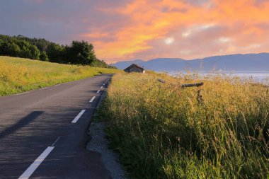 Summer in Norway, colorful sunset at the agricultural area Byneset located near the city Trondheim clipart