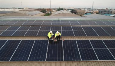Güneş çatısı kurulumu, PPE ve Harness güvenliği olan mühendis fabrikanın çatısına yeşil yenilenebilir enerji, güneş pilleri yerleştirin
