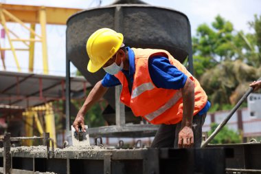 İnşaat işçisi veya işçi beton dökme işlemi yapıyor