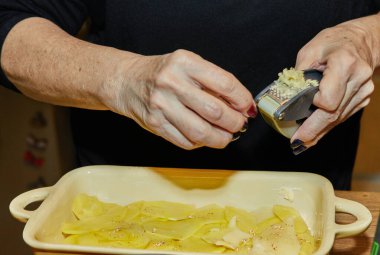 Şef, Patates Gratin 'e sarımsak ve Provencal Bitkilerle Tatlı Patates ekler..