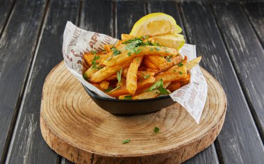Maydanoz ve limonlu patates, ahşap tahtada yağda kızartılmış, kafede servis ediliyor..