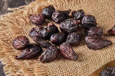 Çuval bezi ve ahşap arka planda kurumuş görev incirleri.