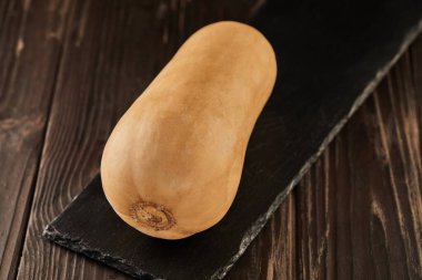 Ahşap zemin üzerinde balkabağı şekilli siyah taş.